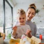 A mother and daughter completing a painting craft.