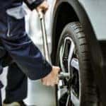 Auto technician changing a tire in a service center