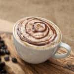 Cappuccino topped with swirls of chocolate sauce.