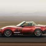 A red racing-spec Mazda Miata on the racetrack.