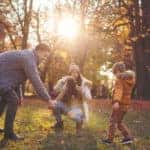 Happy family blowing bubbles at the park