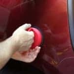 Man fixing car dent by himself