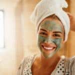 Woman standing in the bathroom with a facial mask