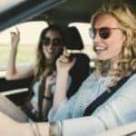 Women driving in the car, singing and enjoying the journey.