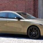 2025 Mazda3 Compact sedan parked in front of a rustic brick bruilding