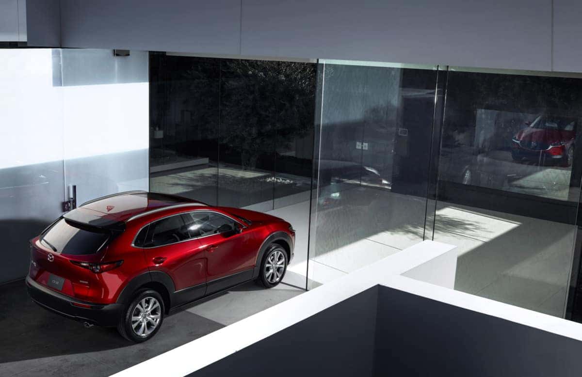 A mazda cx-30 parked in front of a modern minimalist building 