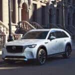 A Mazda CX-90 Family SUV parked in front of some classic architecture