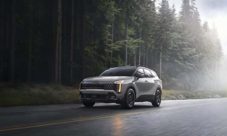 2026 Kia Sportage driving on a forest road