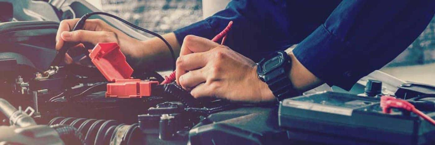 Close up view of a service tech testing a car battery
