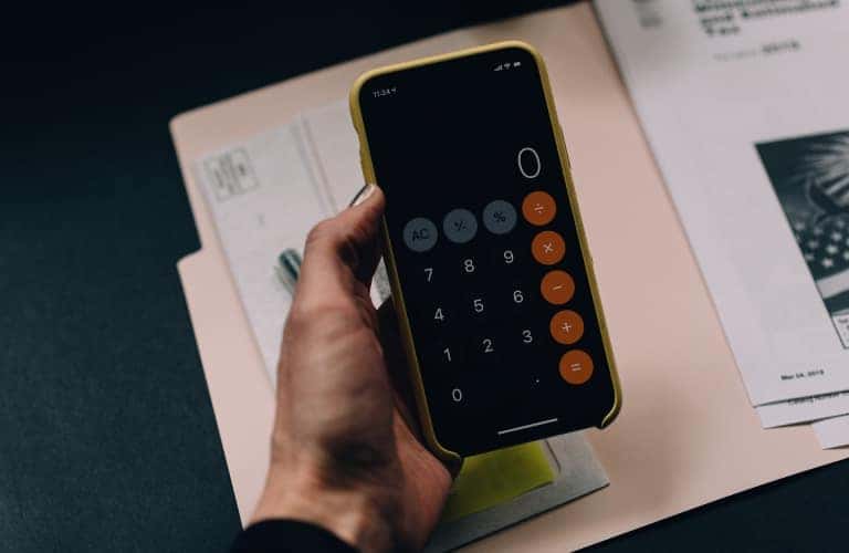 hand holding phone with calculator on screen