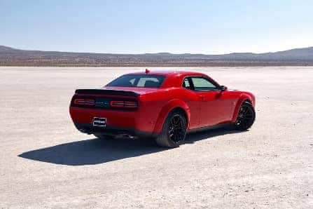 Red 2023 Dodge Challenger in Red Driving in Sand