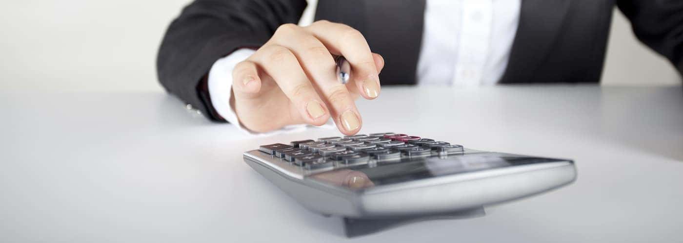close up of woman tapping on calculator