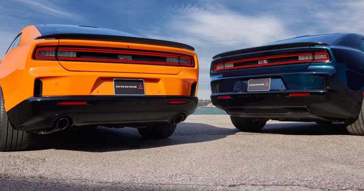 Rear view of a vibrant orange and a deep blue 2026 Dodge Charger Daytona models