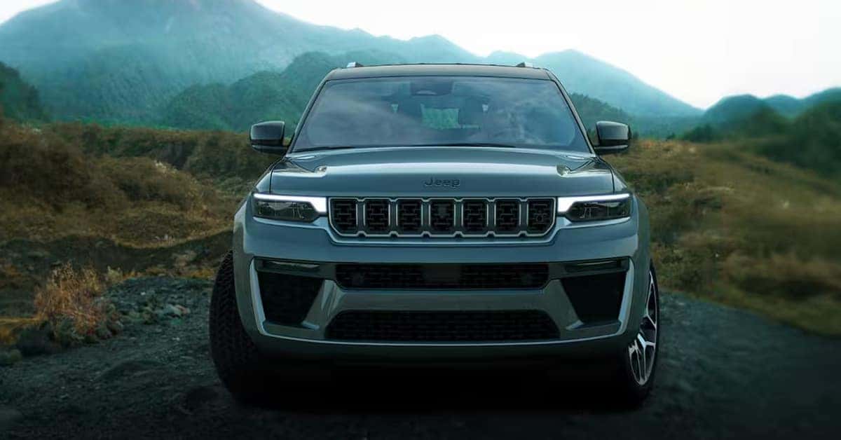 A dark grey 2026 Jeep Grand Cherokee parked on a rocky trail
