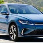 Front three-quarter view of a blue 2026 Volkswagen Jetta sedan parked on a paved road.