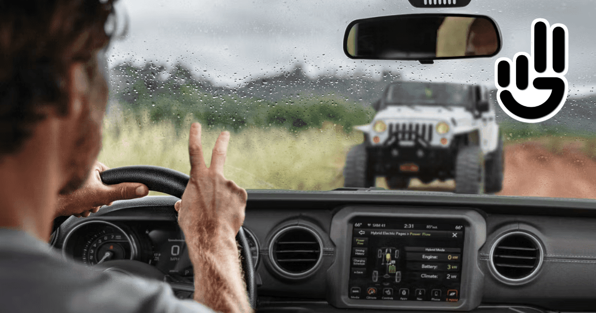 A man driving a jeep waving to a jeep owner